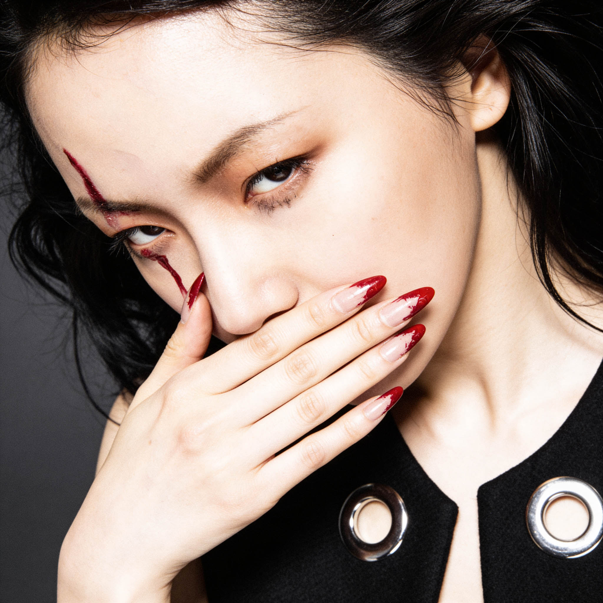 Beauty fashion portrait with bold red styling, red fingernails, and high-end editorial lighting by Ken Jones Photography.